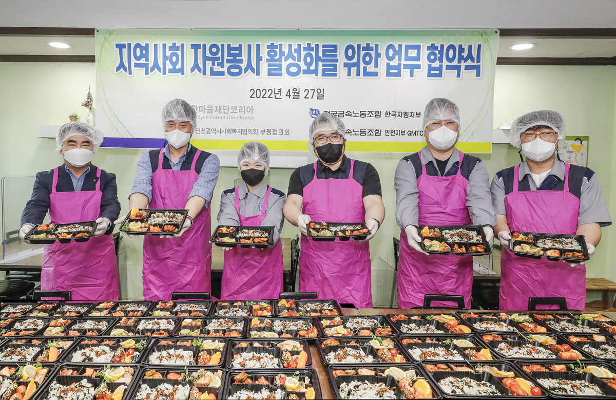 한국지엠 직원들이 취약계층을 위한 무료급식 도시락 들고 기념사진을 촬영하고 있다. [지엠한마음재단코리아 제공]