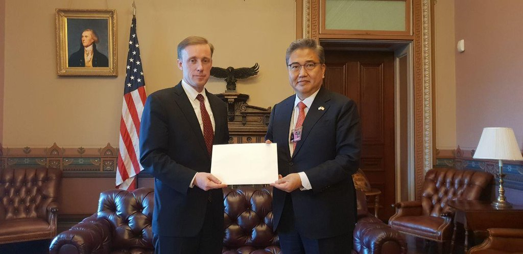 Rep. Park Jin (L) of the main opposition People Power Party, who leads South Korean President-elect Yoon Suk-yeol's policy consultation delegation to the United States, poses with US National Security Adviser Jake Sullivan while handing over Yoon's personal letter to US President Joe Biden at the White House in Washington on April 5, 2022, in this photo provided by the group. (Yonhap)