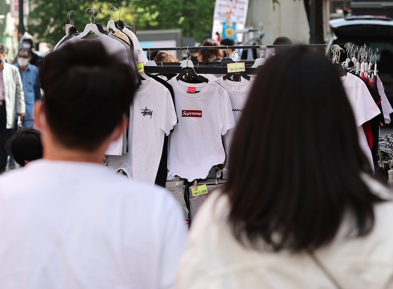 서울 낮 기온이 23도까지 오르며 초여름 날씨를 보인 27일 오후 서울 중구 명동에서 시민들이 반소매 옷 판매대 앞을 지나고 있다. [연합]