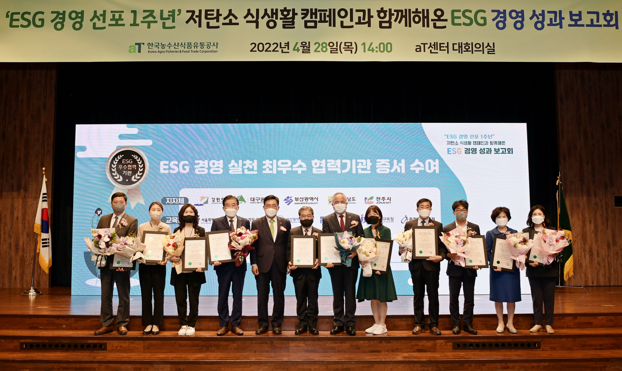 김춘진(왼쪽 다섯번째) 한국농수산식품유통공사 사장이 28일 서울 서초구 양재동 aT센터에서 열린 ESG경영 선포 1주년 성고보고회에서 기념촬영을 하고 있다.[한국농수산식품유통공사 제공]