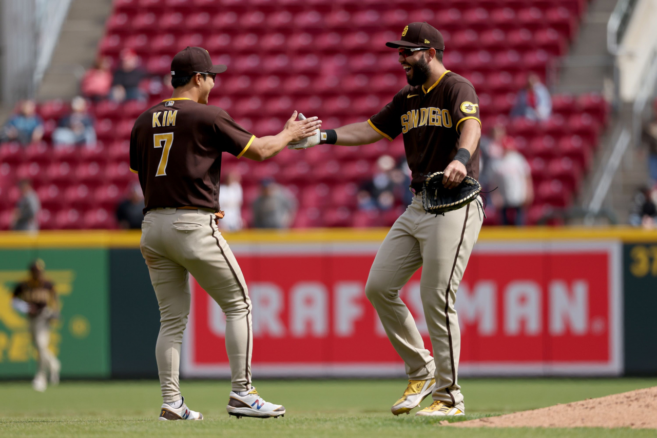In this Getty Images photo, Kim Ha-seong of the San Diego Padres (L) celebrates with teammate Eric Hosmer after their 7-5 victory over the Cincinnati Reds in a Major League Baseball regular season game at Great American Ball Park in Cincinnati on Thursday. (Yonhap)
