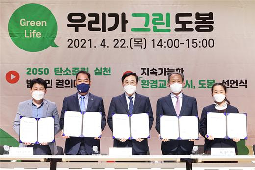 이동진(가운데) 도봉구청장이 지난 달 22일 지구의 날 ‘2050 탄소중립 실천 범구민 결의대회’ 중 도봉구민 온실가스 1인 4톤 줄이기 실천 서약을 하고 있다. [도봉구 제공]