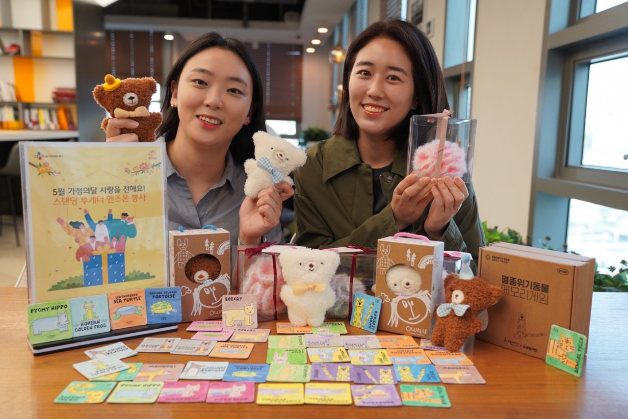 CJ올리브네트웍스 임직원들이 가정의 달을 맞아 제작한 테디베어 키링과 멸종위기동물 메모리카드, 수세미 카네이션 3종 등을 소개하고 있다.[CJ올리브네트웍스 제공]