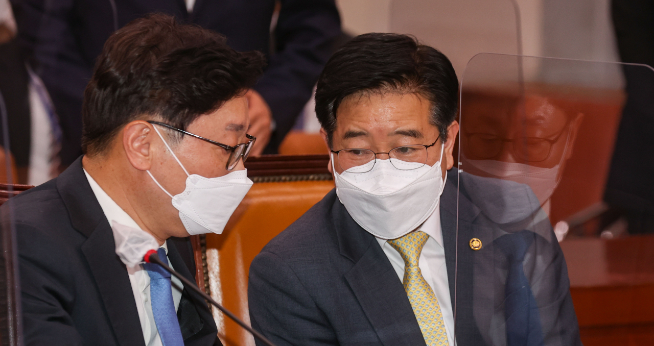 박범계 법무부 장관과 김창룡 경찰청장(오른쪽)이 지난 26일 저녁 국회에서 열린 법제사법위원회 전체회의에서 대화하고 있다. [연합]