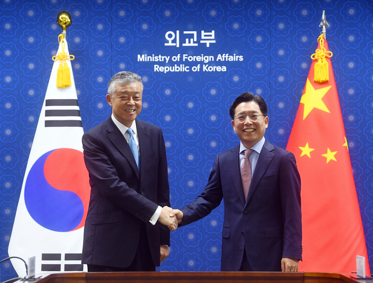 Noh Kyu-duk (R), special representative for Korean Peninsula peace and security affairs, shakes hands with his Chinese counterpart, Liu Xiaoming, ahead of their meeting at the Ministry of Foreign Affairs on Tuesday. (Yonhap)