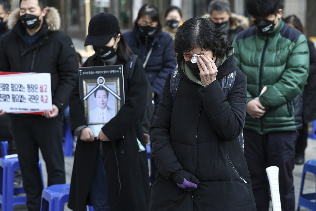 지난 1월 서울 청계광장에서 열린 ‘제10회 백신희생자 추모식 및 촛불집회’에서 코로나19백신피해자가족협의회를 비롯한 참석자들이 묵념을 하고 있다. [연합]