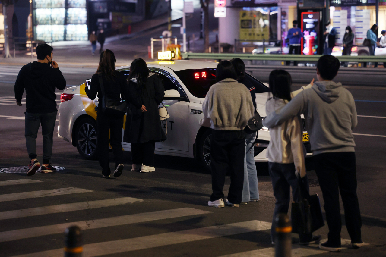 지난달 18일 택시 승차난으로 인해 서울 강남역 인근에서 여러 시민이 빈 택시를 향해 모여들고 있는 모습. [연합]