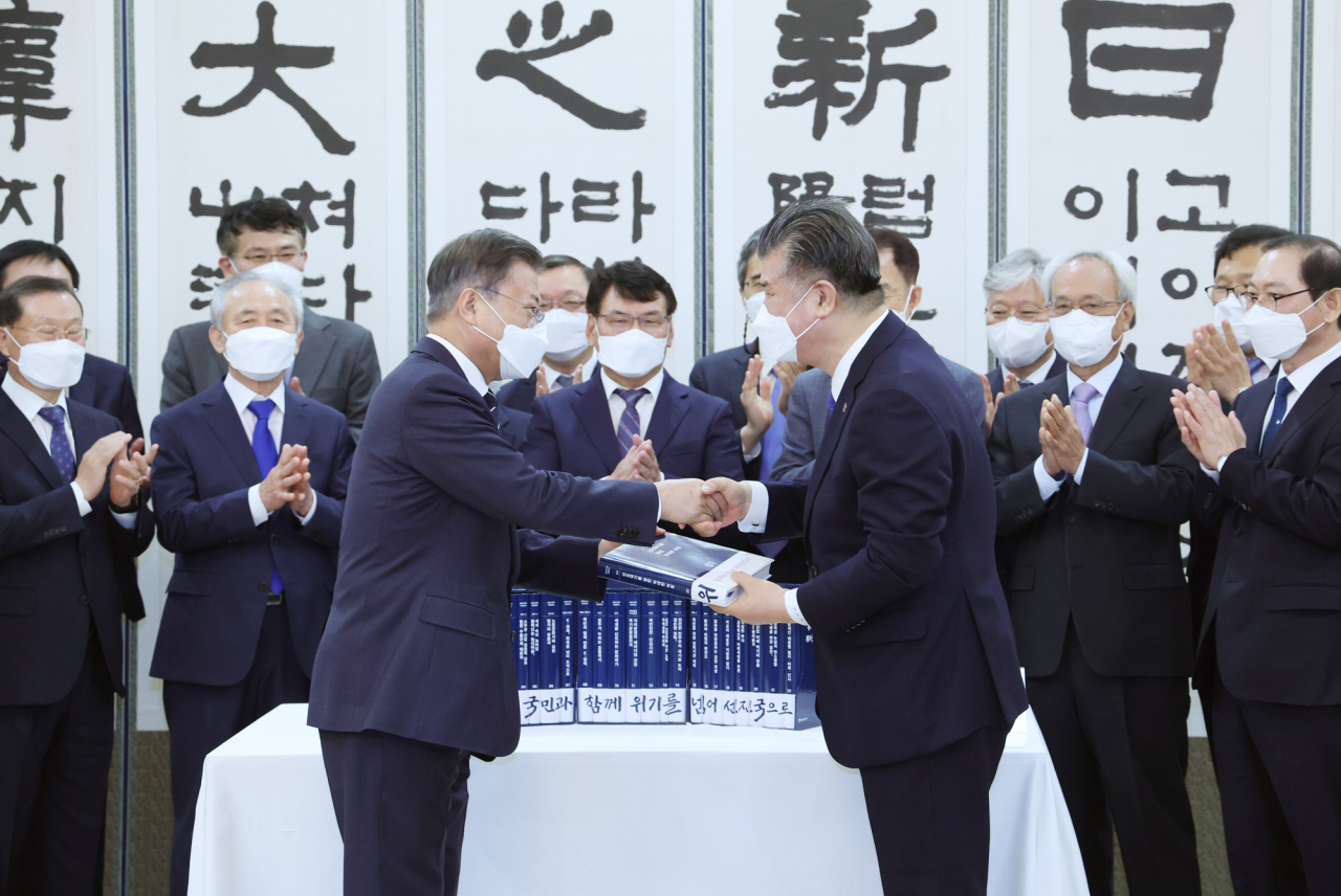 문재인 대통령이 4일 청와대 본관에서 열린 백서 발간 기념 국정과제위원회 초청 오찬에 앞서 조대엽 정책기획위원회 위원장으로부터 백서를 전달받고 있다. 연합뉴스