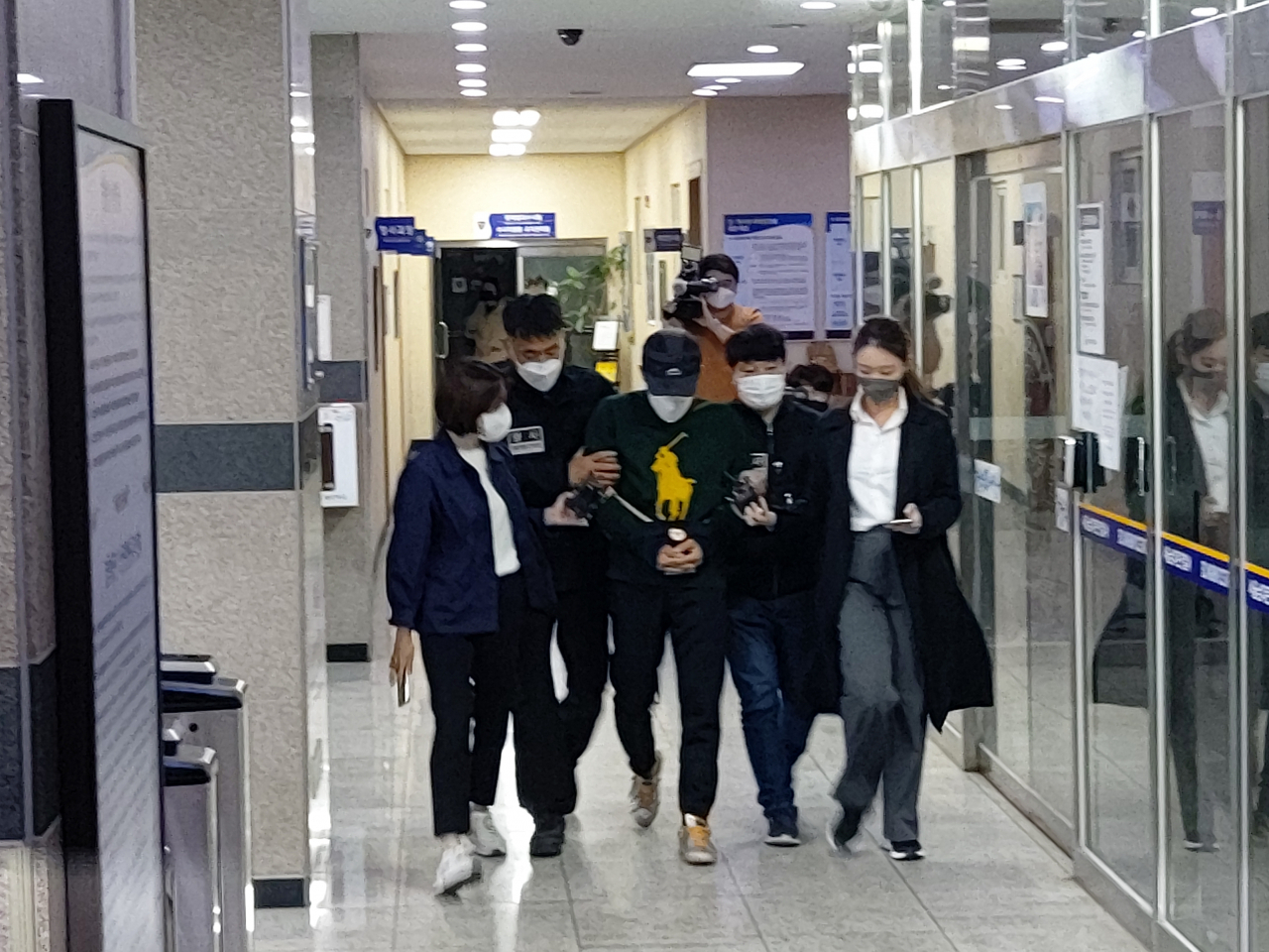 우리은행에서 707억원을 횡령한 직원 전모씨와 공모한 혐의를 받는 동생이 검찰에 송치되면서 서울 남대문경찰서 유치장을 나서고 있다. 김희량 기자
