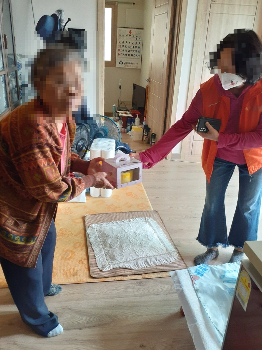 도봉구치매안심센터 치매전문자원봉사자가 치매어르신에게 조호물품과 카네이션 수건케이크를 전달하고 있다. [도봉구 제공]