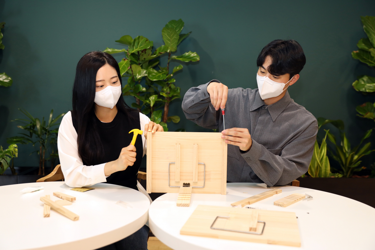 현대글로비스 직원들이 어린이에게 선물할 독서대를 직접 제작하고 있다. [현대글로비스 제공]