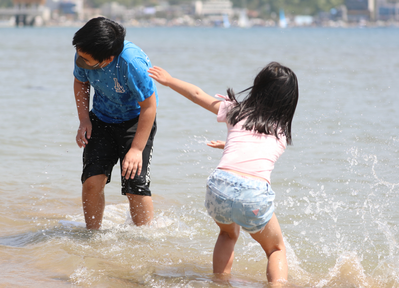 In this file photo, children cool off on a beach in the southeastern city of Pohang on April 24, 2022, when the temperature was unusually high. (Yonhap)