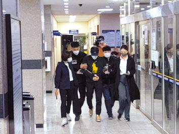 우리은행에서 614억원을 횡령한 직원 A씨와 공모한 혐의를 받는 동생 B씨가 6일 오전 검찰에 송치되면서 서울 남대문경찰서 유치장을 나서고 있다. 김희량 기자