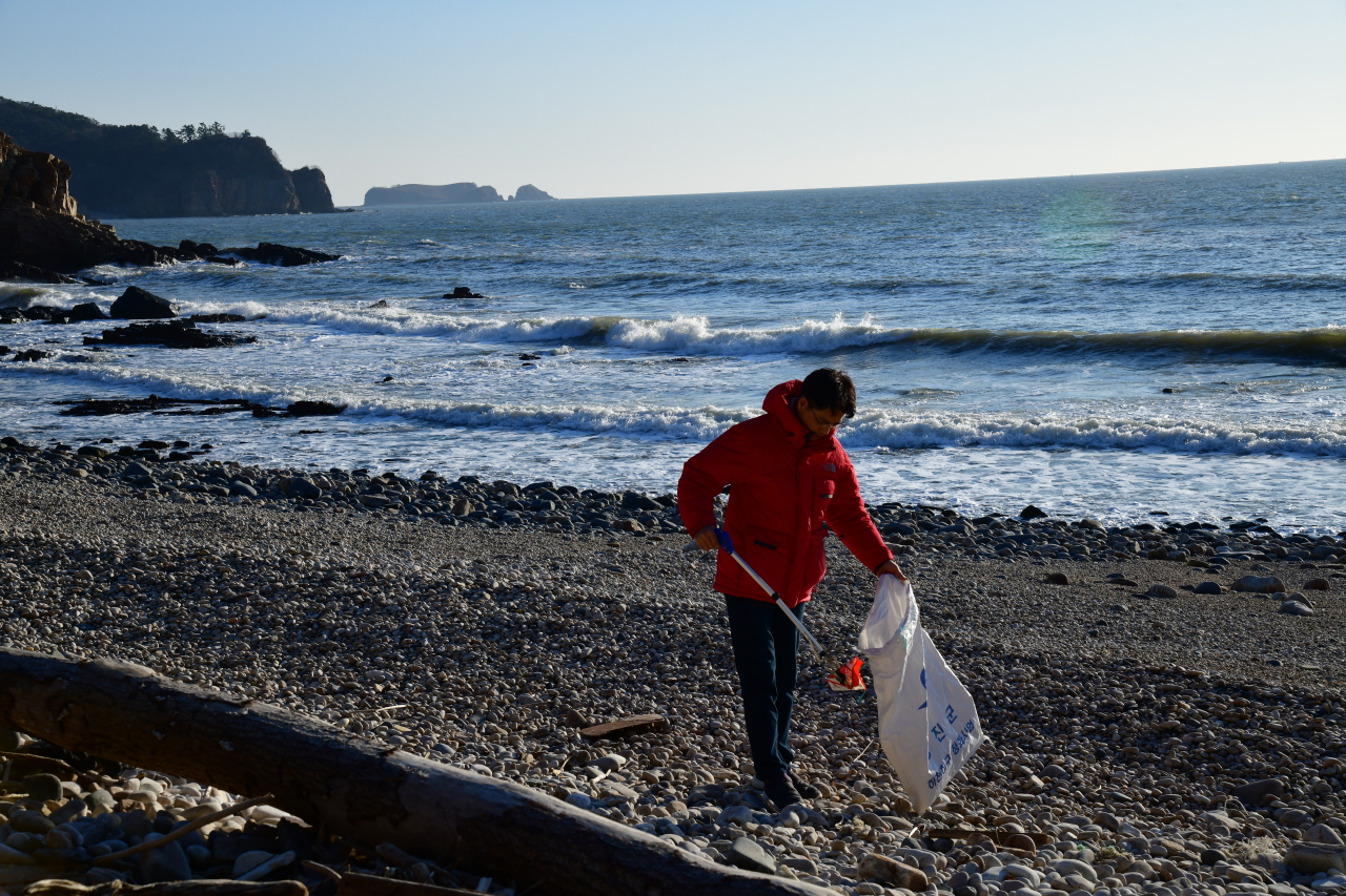 Kang Dong-wan picks up North Korean trash on Yeonpyeong Island, which lies just to the south of the disputed inter-Korean western maritime border, in December 2021. (Photo Credit: Kang Dong-wan)