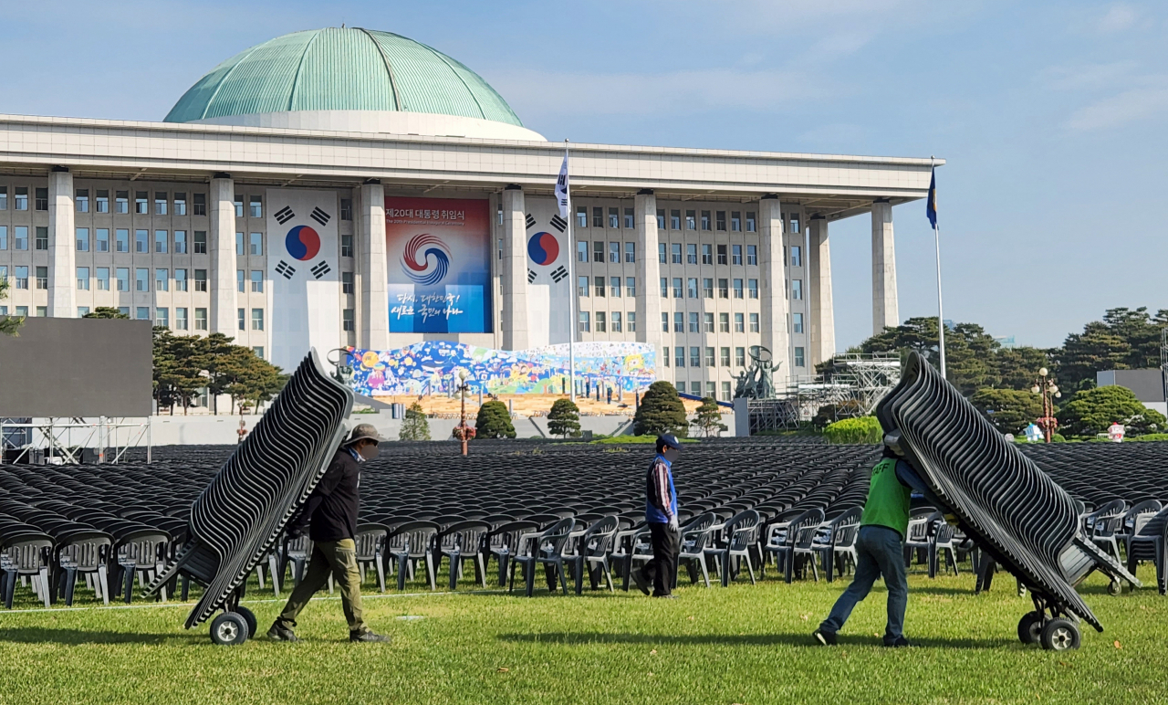제20대 대통령 취임식을 나흘 앞둔 지난 6일 국회 잔디광장에서 관계자들이 취임식 참석자들의 의자를 설치하고 있다. [연합]