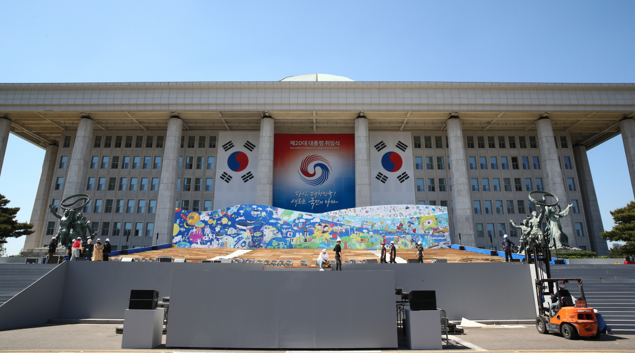 제20대 대통령 취임식을 5일 앞둔 지난 5일 서울 여의도 국회 본관 앞에서 관계자들이 취임식 무대준비를 하고 있다. [연합]