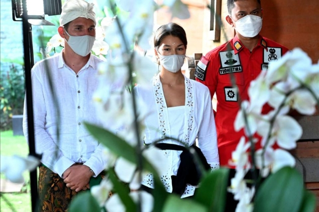 인도네시아 발리섬의 신성한 나무 안에서 나체 사진을 촬영한 혐의로 추방 위기에 몰린 러시아 인플루언서 알리나 파즐리바(가운데)와 남편 안드레이 파즐리브(왼쪽)가 6일 덴파사르의 기자회견에 참석하고 있다.[ 덴파사르 AFP 연합뉴스]