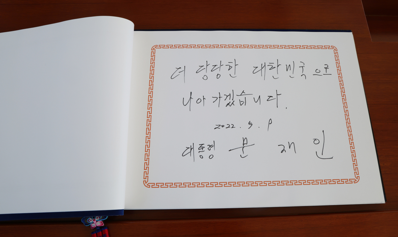 문재인 대통령이 부인 김정숙 여사와 함께 9일 오전 서울 동작구 국립서울현충원을 참배한 뒤 방명록에 "더 당당한 대한민국으로 나아가겠습니다"라는 글을 남겼다. [연합]