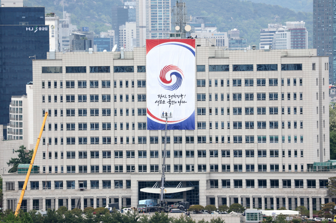 제20대 대통령 취임을 앞둔 지난 8일 오전 대통령 집무실이 들어설 서울 용산구 국방부 청사에 작업자들이 새 정부 출범 기념 현수막을 걸고 있다. [연합]