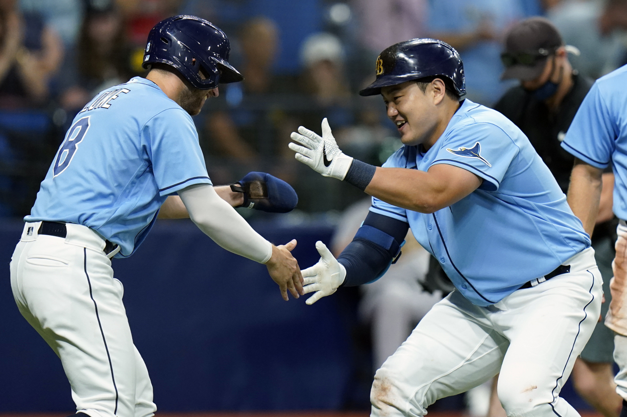 In this Associated Press photo, Choi Ji-man of the Tampa Bay Rays (R) celebrates his three-run home run off Adam Oller of the Oakland Athletics with teammate Brandon Lowe during the bottom of the second inning of a Major League Baseball regular season game at Tropicana Field in St. Petersburg, Florida, on April 12. (AP)