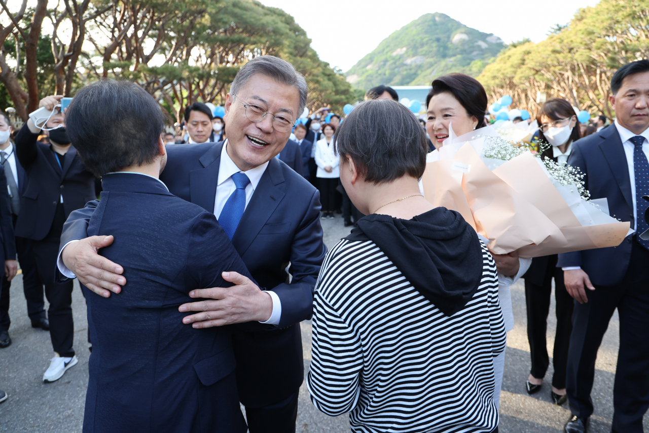 문재인 대통령이 9일 오후 청와대를 나와 분수대 앞으로 향하던 중 꽃다발을 건네준 시민과 포옹하고 있다. [연합]