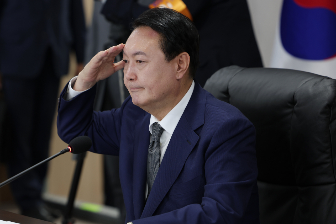 President Yoon Suk-yeol salutes as he receives a briefing from the military in the underground bunker of the new presidential office in Yongsan, Seoul, on Tuesday, in this photo provided by his office. (Yoon's presidential office)