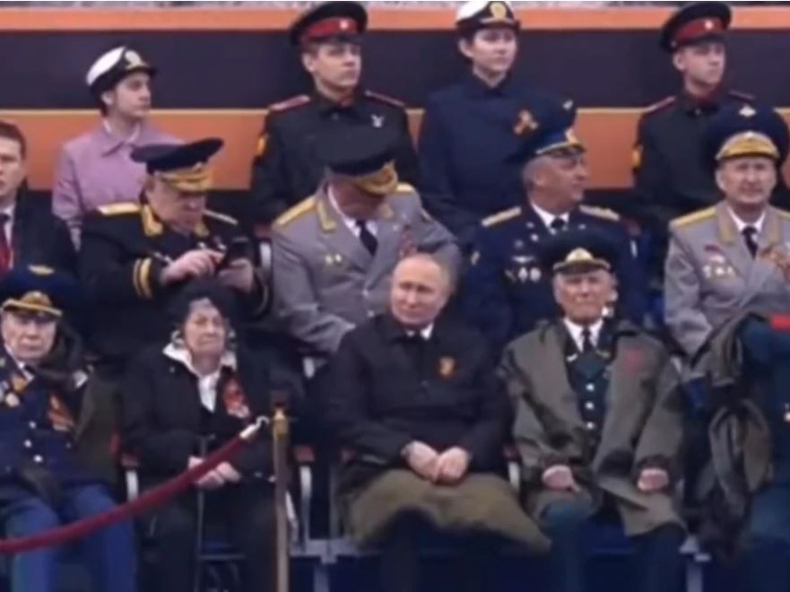 지난 9일(현지시간) 러시아 전승절 열병식에 참석한 블라디미르 푸틴 대통령이 제2차 세계대전 참전 용사들 사이에 앉아 열병식을 관람하고 있다. 사진에선 그만 유일하게 무릎 담요를 썼다. 오른 손을 왼손으로 꼭 감아 쥔 모습이 눈에 띈다. [러시아 채널1 캡처]