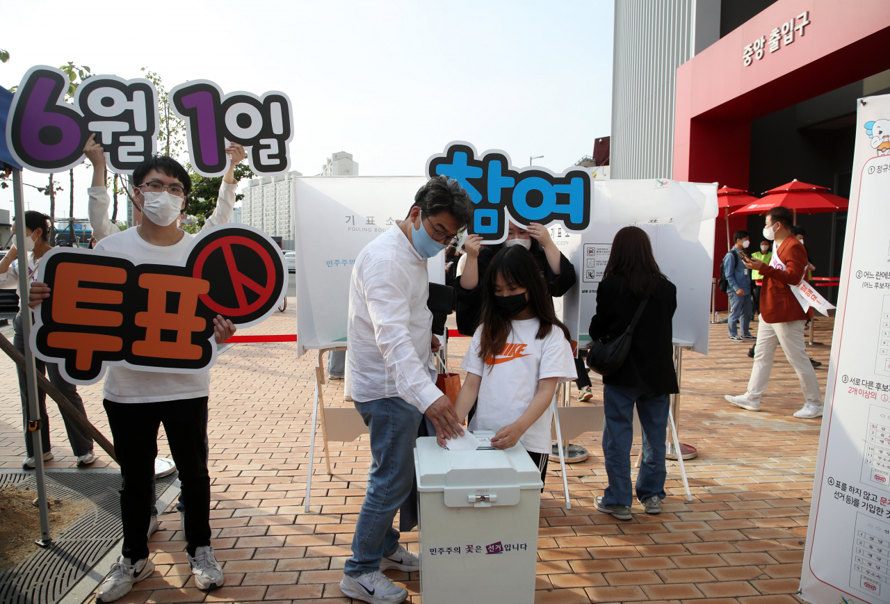 6월 1일 치러지는 제8회 전국동시지방선거를 3주 앞둔 11일 광주기아챔피언스필드에서 열린 광주시선관위의 투표 체험행사에 참여한 부녀가 기표 용지를 투표함에 넣고 있다. [연합]
