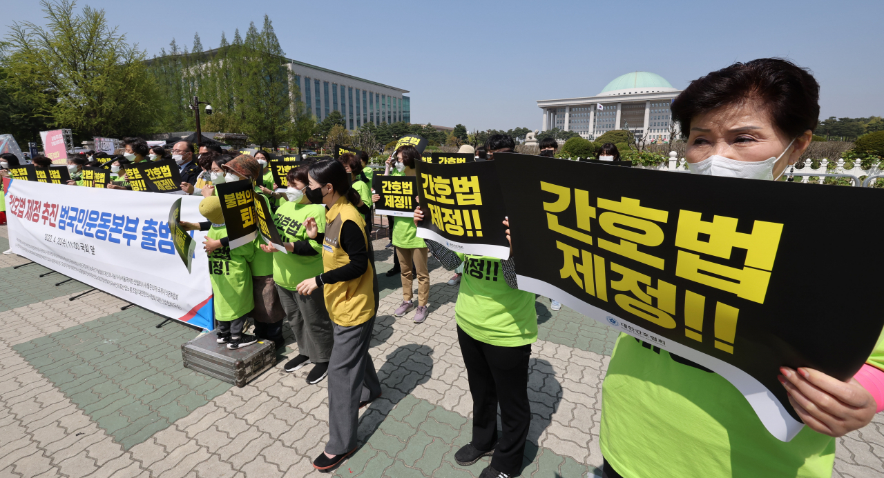 지난달 20일 국회의사당 정문 앞에서 열린 간호법 제정 추진 범국민운동본부 출범식 기자회견에서 대한간호협회 회원 등 참가자들이 손팻말을 들고 있다. [연합]
