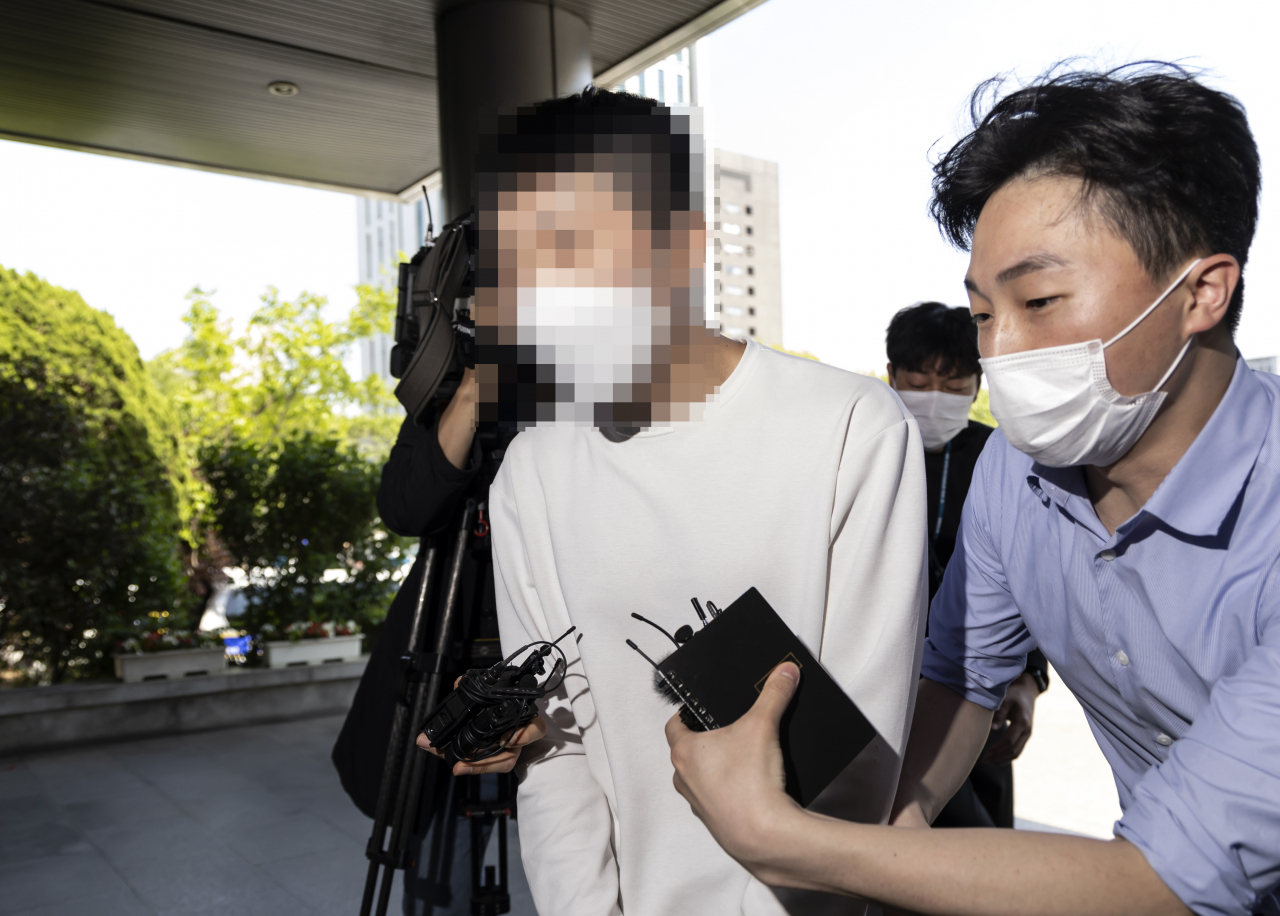 대통령 취임식에 테러를 하자는 내용의 글을 한 온라인 커뮤니티에 올린 20대 후반 남성 A씨가 경찰에 검거돼 취임식 당일이었던 지난 10일 오후 서울 서초경찰서로 들어서고 있다. A씨는 지난 9일 오후 10시35분께 온라인 커뮤니티 보배드림에 ‘내일 취임식에 수류탄 테러하실 분 구합니다’라는 제목의 글을 게시했다. [연합]