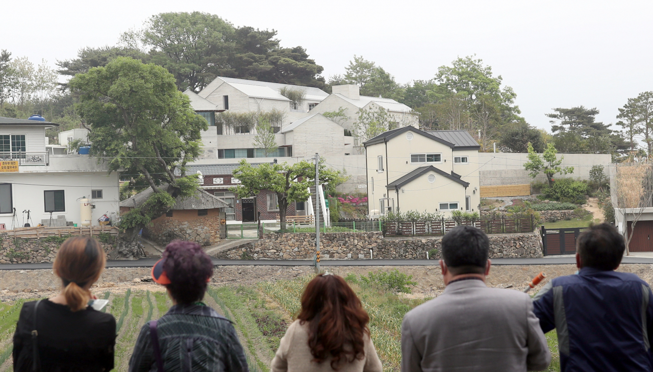 경남 양산시 하북면 평산마을 문재인 전 대통령 내외 사저 맞은편 길가에 사람들이 문 전 대통령 사저를 바라보고 있다. [연합]