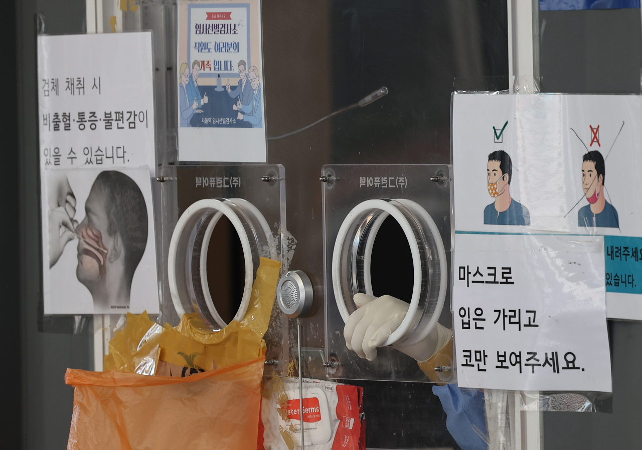 13일 서울 중구 서울역 광장 코로나19 임시 선별검사소에서 의료진이 검체 채취를 마친 뒤 대기하고 있다. [연합]
