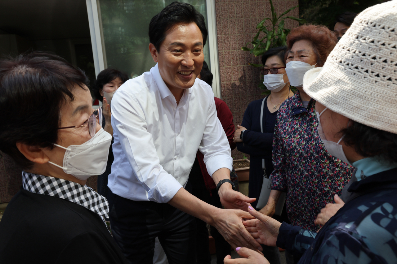 오세훈 국민의힘 서울시장 후보가 지난 13일 서울시 서대문구 세검정로 한 아파트 관리사무소 앞에서 서울형 고품질 임대주택 건설계획을 발표한 뒤 주민과 인사하고 있다. [연합]
