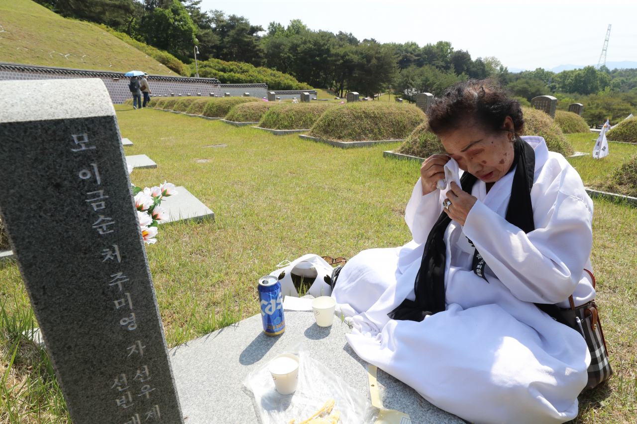 광주 북구 국립 5·18 민주묘지에서 열린 추모제에 참석한 유족이 가족 열사의 묘소 앞에서 오열하고 있다. 연합뉴스