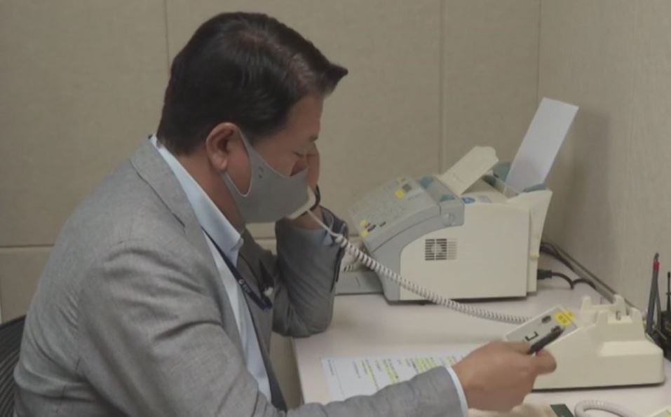 This file photo, provided by the unification ministry, shows a South Korean liaison officer talking to his North Korean counterpart at the Seoul bureau of their joint liaison office on Oct. 4, 2021. (Yonhap)