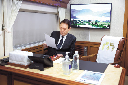 윤석열 대통령이 18일 오전 제42주년 5·18 광주민주화운동 기념식에 참석하기 위해 서울역에서 KTX 특별열차에 탑승, 자료를 검토하고 있다. [연합]