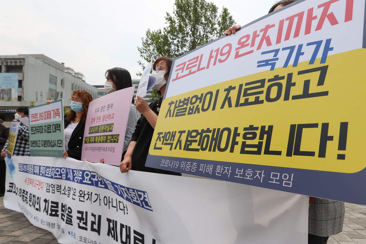 코로나19 위중증 피해 환자 보호자 모임 관계자들이 18일 서울 용산구 대통령 집무실 인근에서 ‘새 정부 요구안’ 발표 기자회견을 하고 있다. 연합뉴스