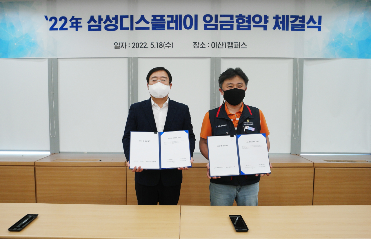 18일 삼성디스플레이 아산1캠퍼스에서 열린 '2022년 임금협약 체결식'에서 윤성희(왼쪽) 인사팀장 부사장과 권상욱 노조 위원장 등 노사 위원들이 협약하는 모습 [삼성디스플레이 제공]