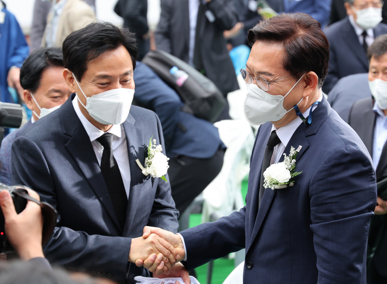오세훈 국민의힘 서울시장 후보(왼쪽)와 송영길 더불어민주당 서울시장 후보가 18일 서울시 서대문구 서대문형무소 역사관 마당에서 열린 5·18 민주화운동 기념일 서울행사에서 인사하고 있다. [연합]