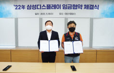 18일 열린 ‘2022년 임금협약 체결식’에서 윤성희(왼쪽) 인사팀장 부사장과 권상욱 노조 위원장 등 노사 위원들이 협약하는 모습. [삼성디스플레이 제공]