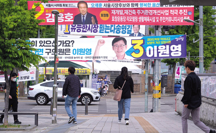 6·1 지방선거 공식 선거운동 이틀째인 20일 오전 서울 용산구 효창공원역 사거리에 지방선거 후보들의 현수막이 걸려 있는 가운데 시민이 오가고 있다. 이번 지방선거에서 여당인 국민의힘은 정권안정론을 호소하며 수도권 압승을 자신하고 있고, 야당인 더불어민주당은 정권견제론으로 경기 지역을 비롯한 총력적인 사수 전략으로 맞서고 있다. 이로써 다음달 1일을 향한 정치권의 선거운동 열기는 후끈 달아오르고 있다. 이상섭 기자