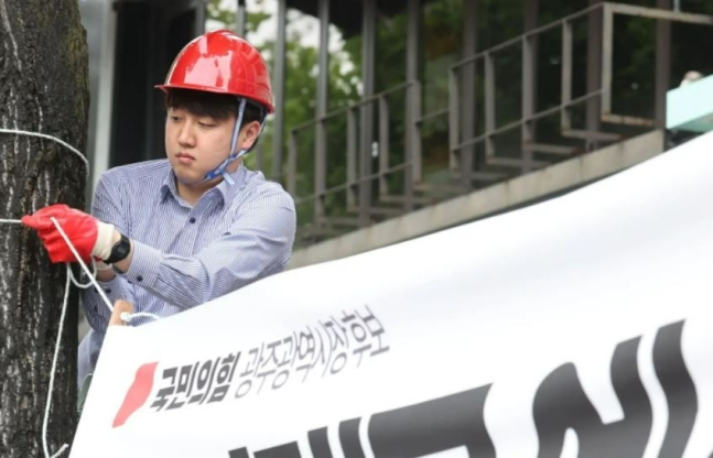 이준석 국민의힘 대표가 20일 광주에서 새 현수막으로 교체하고 있다. [페이스북]