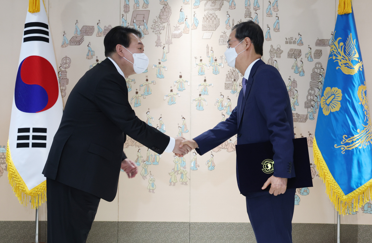 윤석열 대통령이 21일 서울 용산 대통령실 청사에서 한덕수 국무총리에게 임명장을 수여한 뒤 악수하고 있다. [연합]