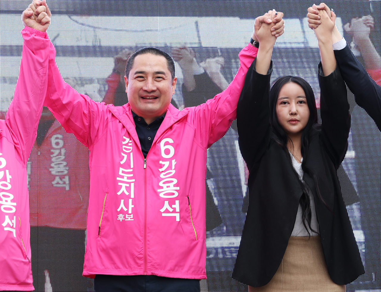무소속 강용석 경기도지사 후보가 지난 19일 오후 경기도 용인중앙시장에서 열린 유세에서 정유라 씨와 손을 맞잡고 높이 들고 있다. [연합]