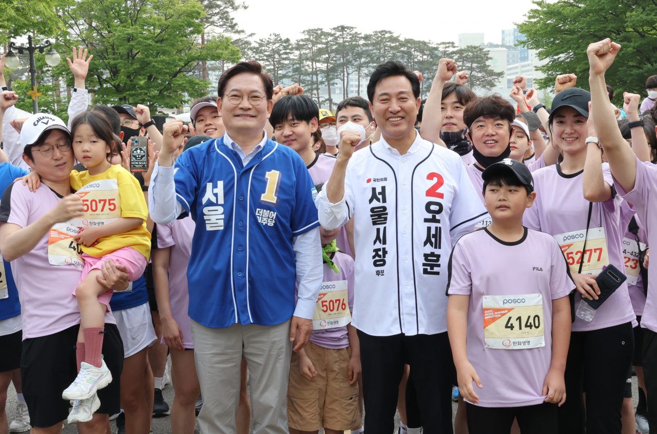 더불어민주당 송영길 서울시장 후보와 국민의힘 오세훈 서울시장 후보가 21일 오전 서울시 마포구 월드컵경기장 평화의 광장에서 열린 2022 서울신문 마라톤 대회에서 참가자들과 함께 출발선에 함께 서 있다. [연합]