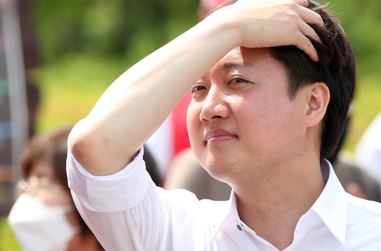이준석 국민의힘 대표가 21일 강원 춘천시 에티오피아한국전참전기념관 앞에서 열린 합동유세에서 앞머리를 쓸어넘기고 있다. [연합]