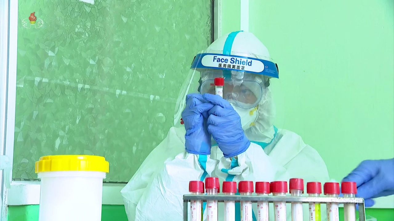 A North Korean medical worker wearing a face shield, believed to be made in China, collects test samples amid a surge in suspected coronavirus cases, in this photo captured from the North's official Korean Central Television. Last Friday, North Korea reported more than 263,370 cases of what it refers to as "fever" and two more deaths in the 24 hours through 6 p.m. the previous day. (Yonhap)