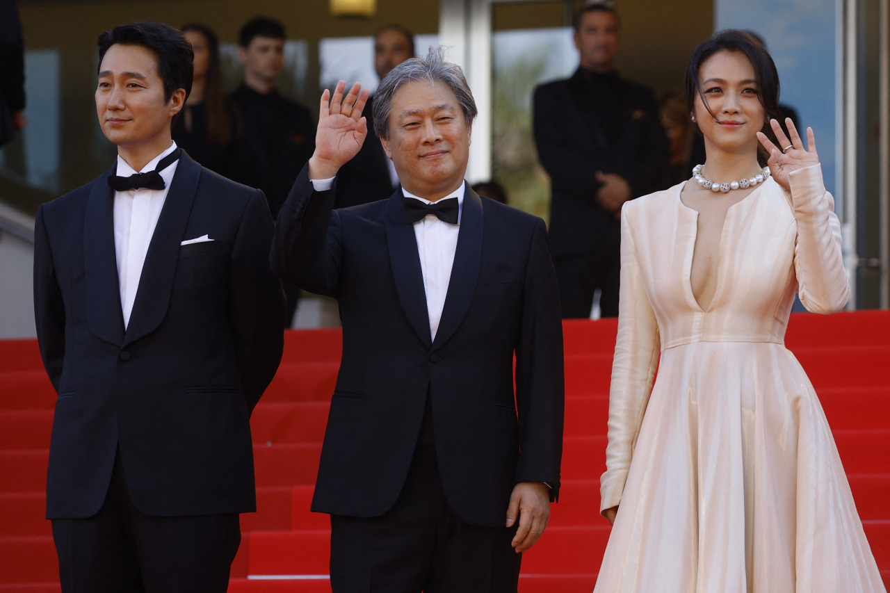 In this Reuters photo, Korean director Park Chan-wook (C) and cast members Park Hae-il (L) and Tang Wei (R) arrive for the screening of "Decision to Leave" at the 75th Cannes Film Festival in Cannes, France, on Monday. (Reuters)
