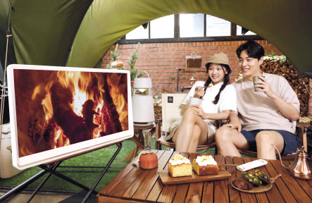 LG전자 LG 룸앤TV 신제품을 통해 서울시 강남구에 위치한 캠핑 카페 글락(GLAC)에서 콘텐츠를 감상하고 있다. [LG전자 제공]