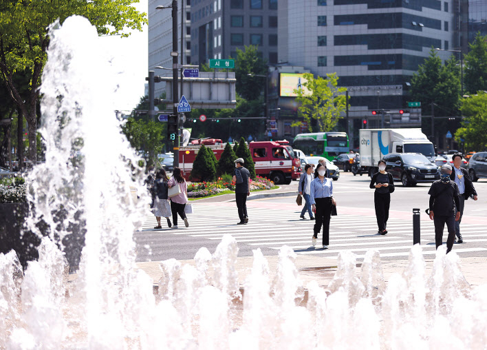 지난 16일 오후 시민들이 서울 중구 서울시청 앞 서울광장 분수대 옆을 걸어가고 있다.[연합]